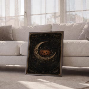 Vintage halloween moon wall art print leaning against a white sofa in a bright living room with sheer curtains.