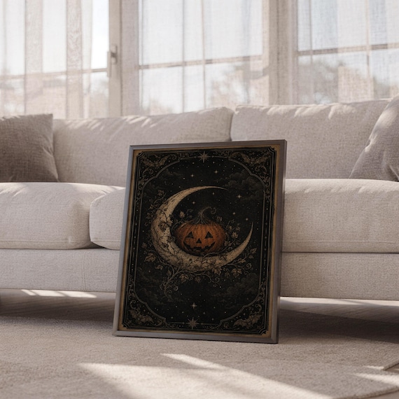 Vintage halloween moon wall art print leaning against a white sofa in a bright living room with sheer curtains.