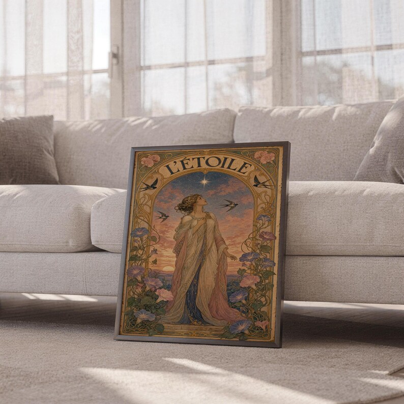 A dark-framed art nouveau L Etoile print resting on the floor between sections of a beige sectional sofa.