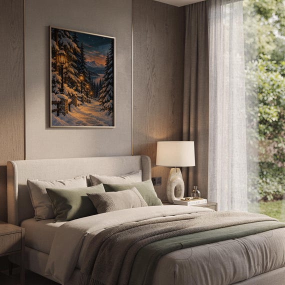 Snowy forest path wall art print hanging above a bed with sage green pillows in a calm neutral bedroom.