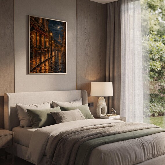 Paris eiffel tower wall art print hanging above a bed with sage green pillows in a calm neutral bedroom.