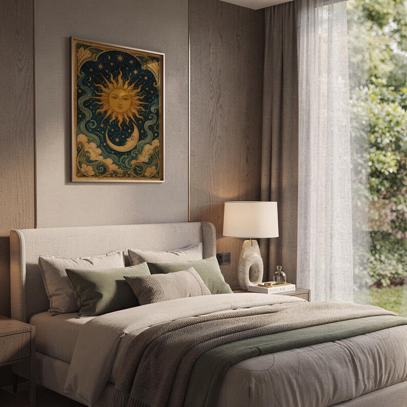 Celestial sun and moon wall art print hanging above a bed with sage green pillows in a calm neutral bedroom.