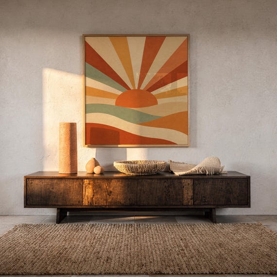 Retro geometric sunrise print hanging above a dark wood console and jute rug in a warm neutral interior.