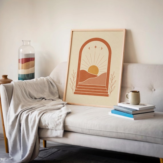 Mid century desert landscape poster leaning against wall next to soft gray sofa