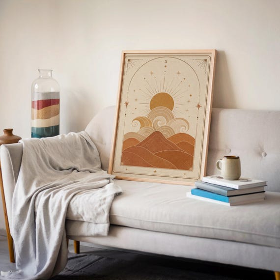 Celestial ocean waves print framed on beige sofa with soft blanket and books in living room decor.