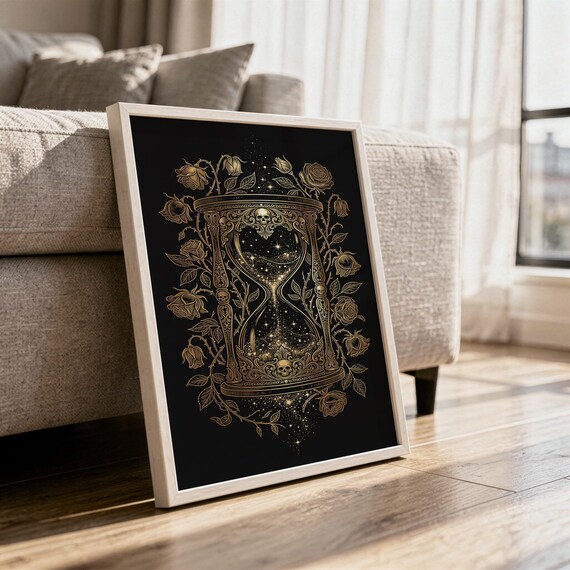Gothic hourglass wall art print in a white frame leaning against a gray sofa on a sunlit wooden floor.