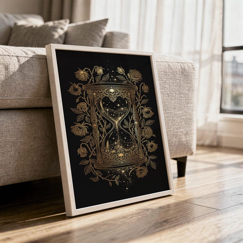 Gothic hourglass wall art print in a white frame leaning against a gray sofa on a sunlit wooden floor.