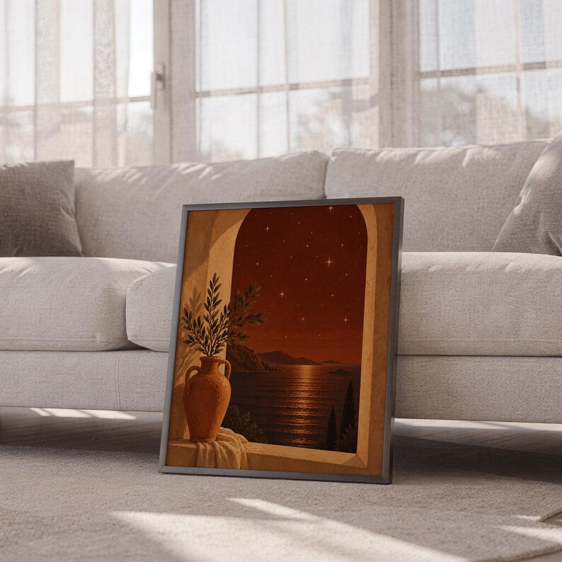 Mediterranean night sea wall art print leaning against a white sofa in a bright living room with sheer curtains.