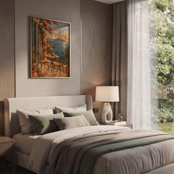 Mediterranean balcony wall art print hanging above a bed with sage green pillows in a calm neutral bedroom.