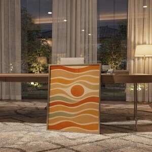 Abstract wavy sun print standing on a wooden desk in a home office in warm evening light.