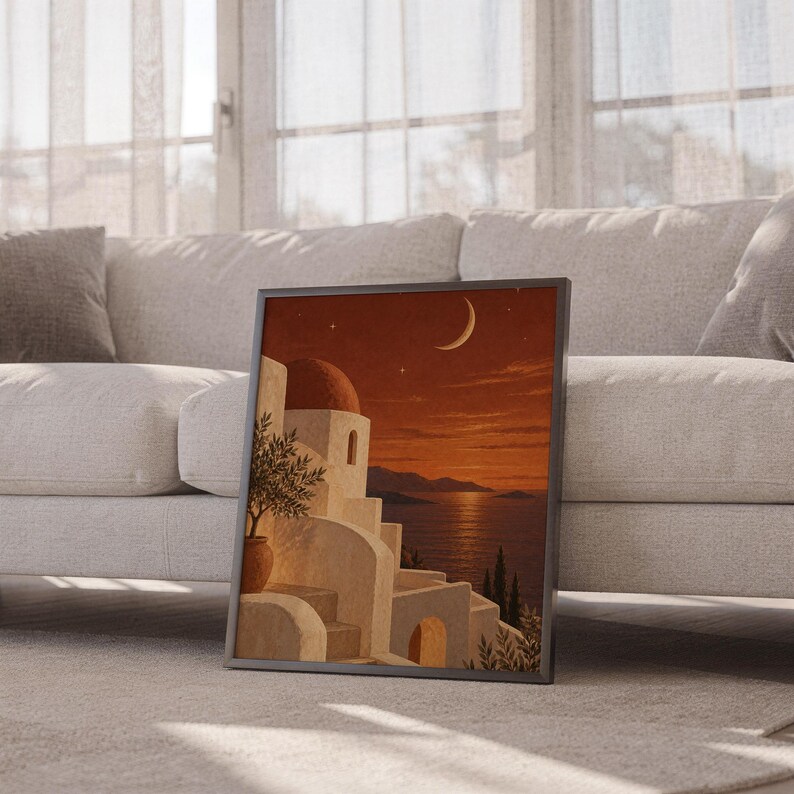 Mediterranean moonlit coastal wall art print leaning against a white sofa in a bright living room with sheer curtains.