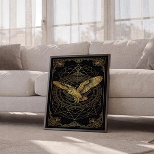 Celestial owl wall art print leaning against a white sofa in a bright living room with sheer curtains.