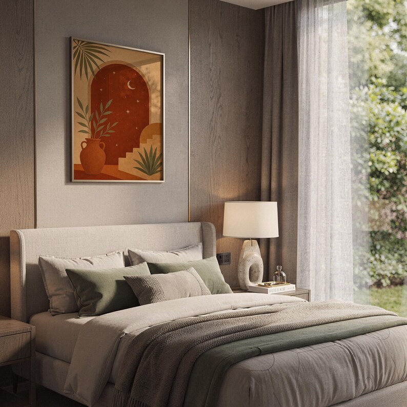 Terracotta moon and stars arch art print hanging above a bed with sage green pillows in a calm neutral bedroom.