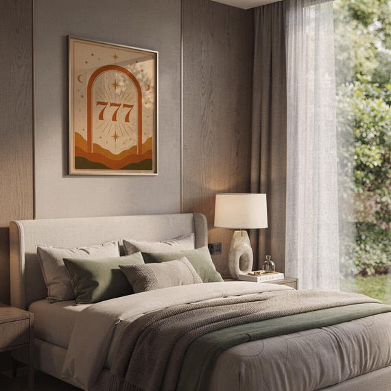 Terracotta 777 angel number print in a wooden frame hanging above a modern bedroom headboard with neutral bedding.