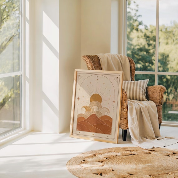 Aesthetic boho sun and waves print leaning on floor near armchair in sunlit room.