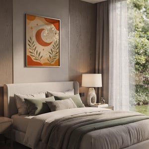 Terracotta crescent moon and olive branch print hanging above a bed with sage green pillows in a calm neutral bedroom.