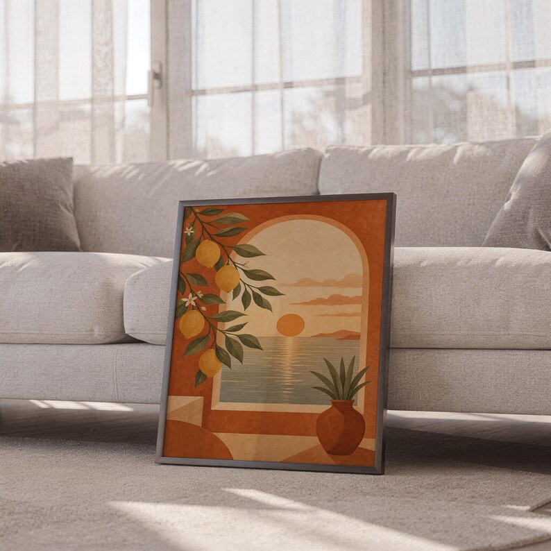 Mediterranean lemon and sea view arch print leaning against a white sofa in a bright living room with sheer curtains.