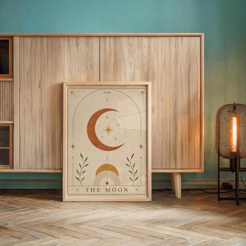 Mid century spiritual moon wall art framed on wooden console table against accent wall.