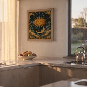 Celestial sun and moon wall art print hanging above a stone countertop with a fruit bowl in a sunny kitchen.