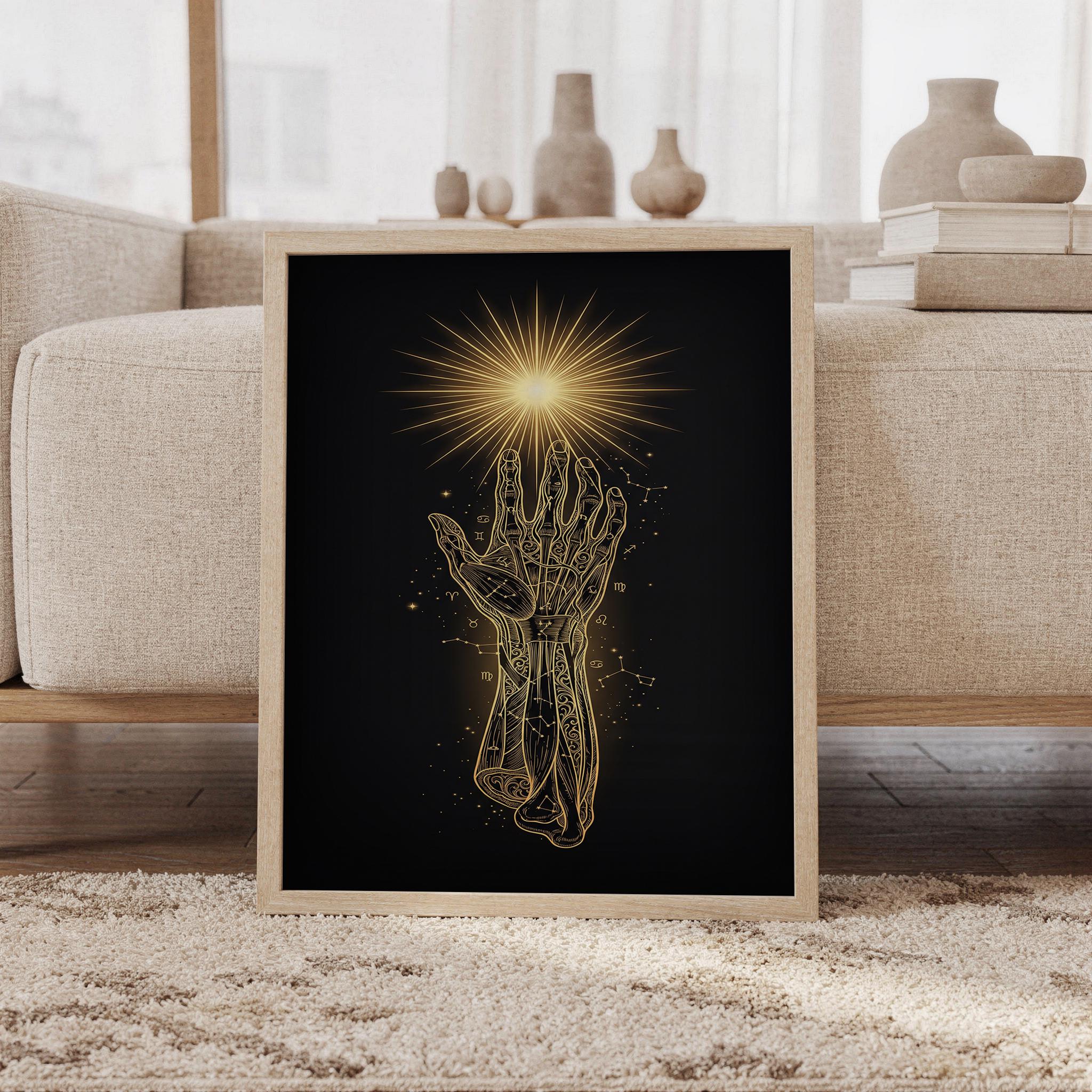 Celestial hand wall art print featuring luminous gold linework, an intricately detailed palmistry hand, zodiac symbols, constellations, and a radiant sunburst on a deep black background, framed and leaning against a beige sofa on a textured rug in a bright Scandinavian living room.