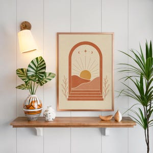 Boho desert wall art on floating wooden shelf above indoor green plants