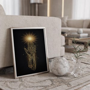 Celestial hand wall art print standing on a countertop in a modern white kitchen.