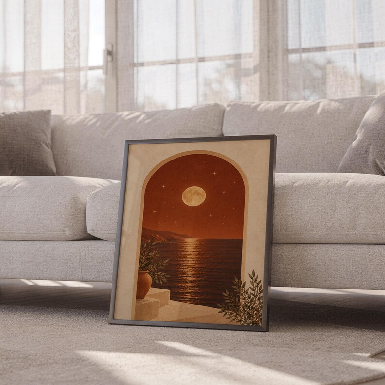 Moonlit Mediterranean arch print leaning against a white sofa in a bright living room with sheer curtains.