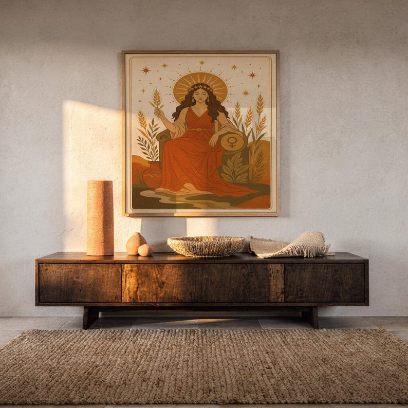 Celestial goddess wall art print hanging above a dark wood console and jute rug in a warm neutral interior.