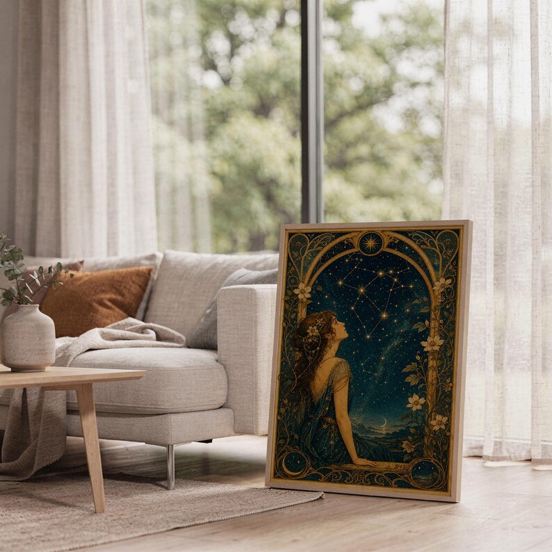 Celestial woman wall art print leaning on the floor beside a cream armchair next to large garden windows.