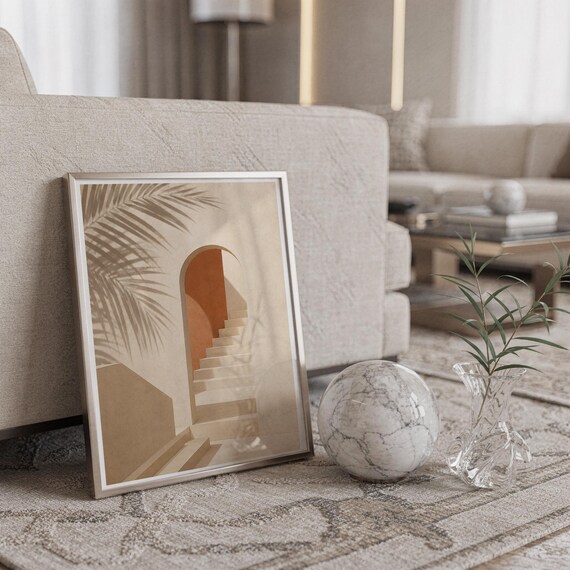 Framed poster leaning on the floor next to a marble sphere object in a bright room.