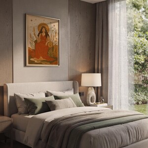 Celestial goddess wall art print hanging above a bed with sage green pillows in a calm neutral bedroom.