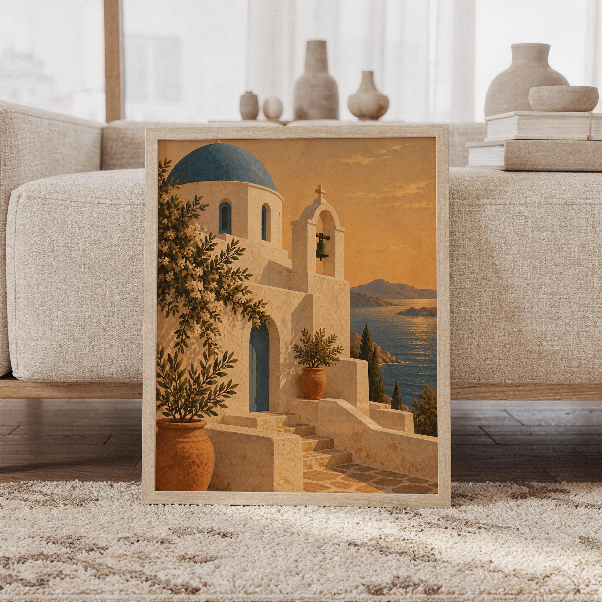 Santorini church wall art print featuring warm terracotta and golden sunset tones, a blue-domed white stone chapel, olive branches, terracotta pots, and a tranquil sea view, framed and leaning against a beige sofa on a textured rug in a bright Scandinavian living room.