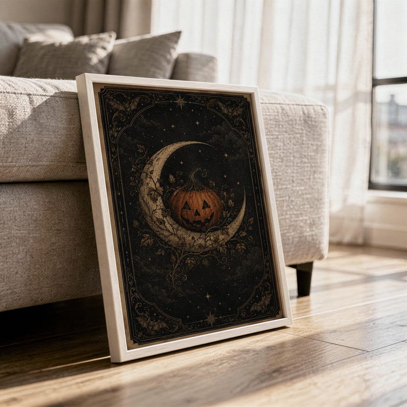 Vintage halloween moon wall art print in a white frame leaning against a gray sofa on a sunlit wooden floor.