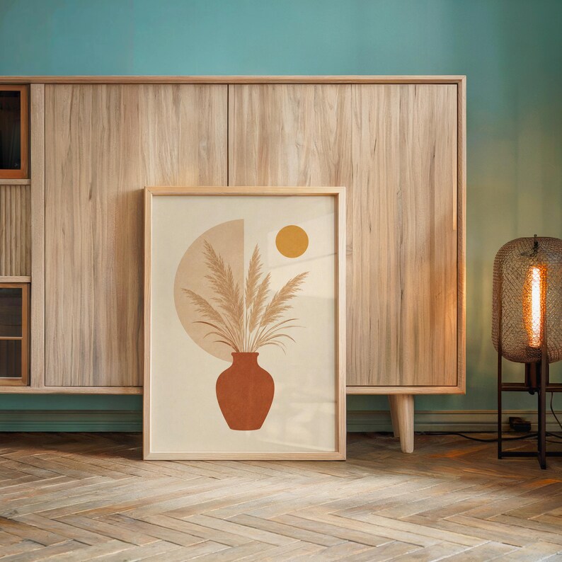 Large pampas grass print leaning against wooden sideboard cabinet