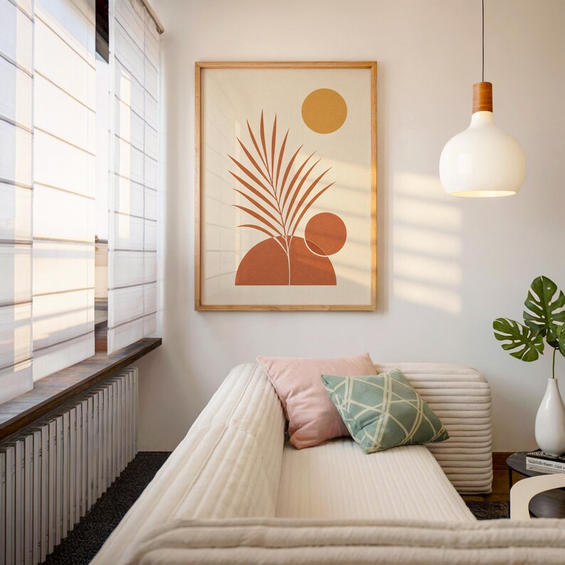 Boho palm leaf wall art with terracotta sun framed above modern sofa in sunlit room