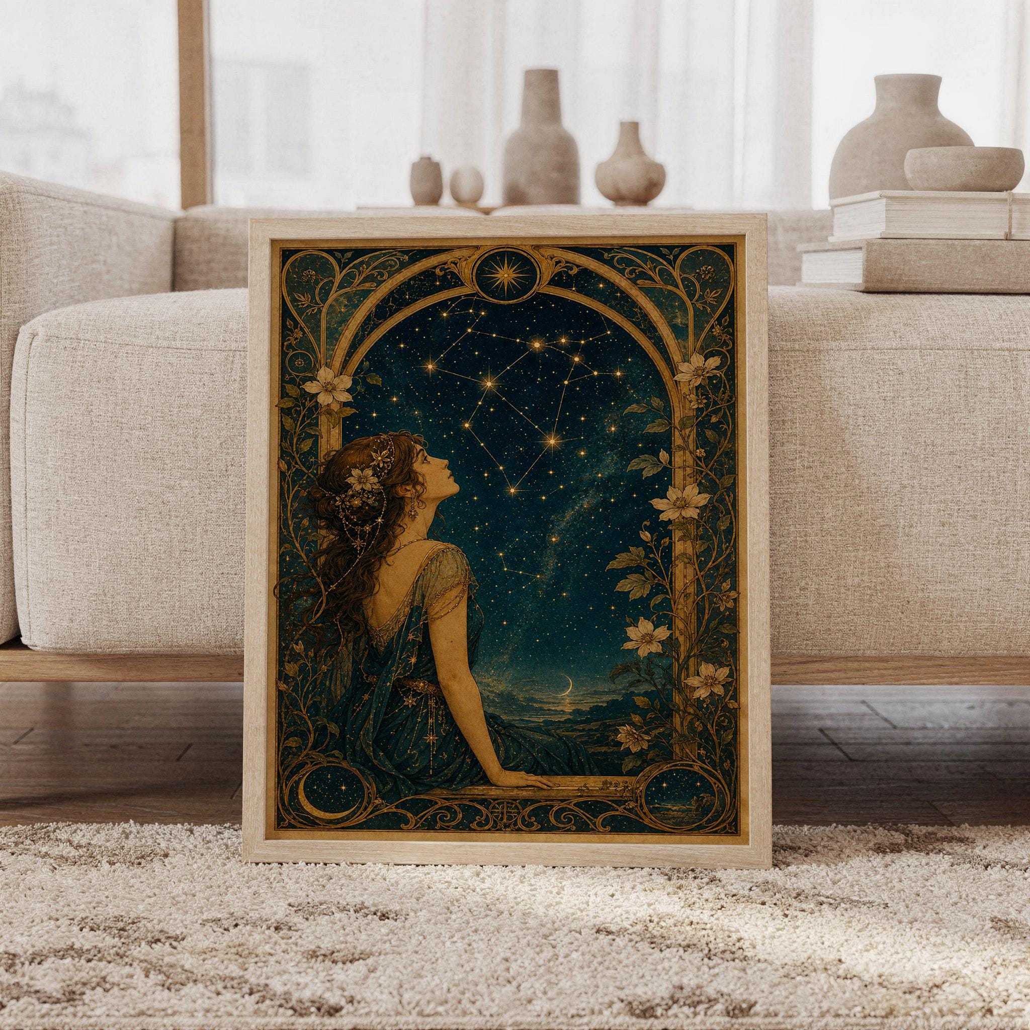 Celestial woman wall art print featuring deep midnight blue, antique gold, warm sepia, and cream tones, a stargazing woman, glowing constellations, crescent moon, and ornate Art Nouveau florals, framed and leaning against a beige sofa on a textured rug in a bright Scandinavian living room.