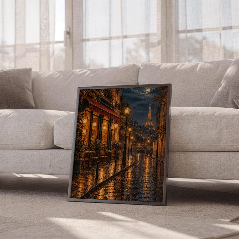 Paris eiffel tower wall art print leaning against a white sofa in a bright living room with sheer curtains.