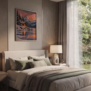 Winter cabin mountain wall art print hanging above a bed with sage green pillows in a calm neutral bedroom.