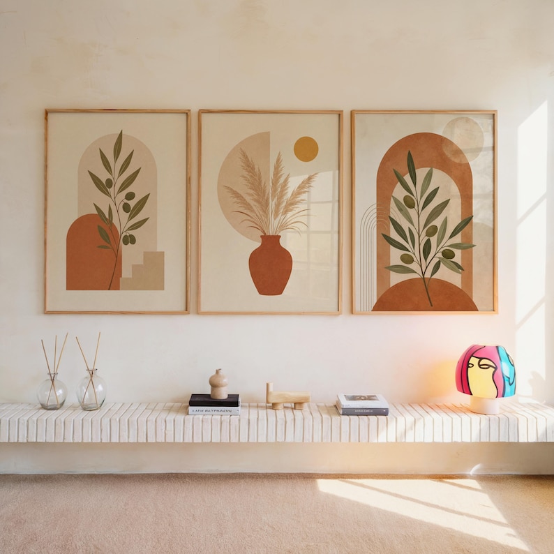 Set of 3 framed boho botanical art prints with terracotta arches and olive branches hanging above a shelf.