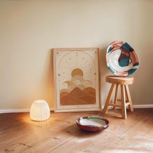 Minimalist neutral wall art poster framed on wooden floor with ambient night lamp.