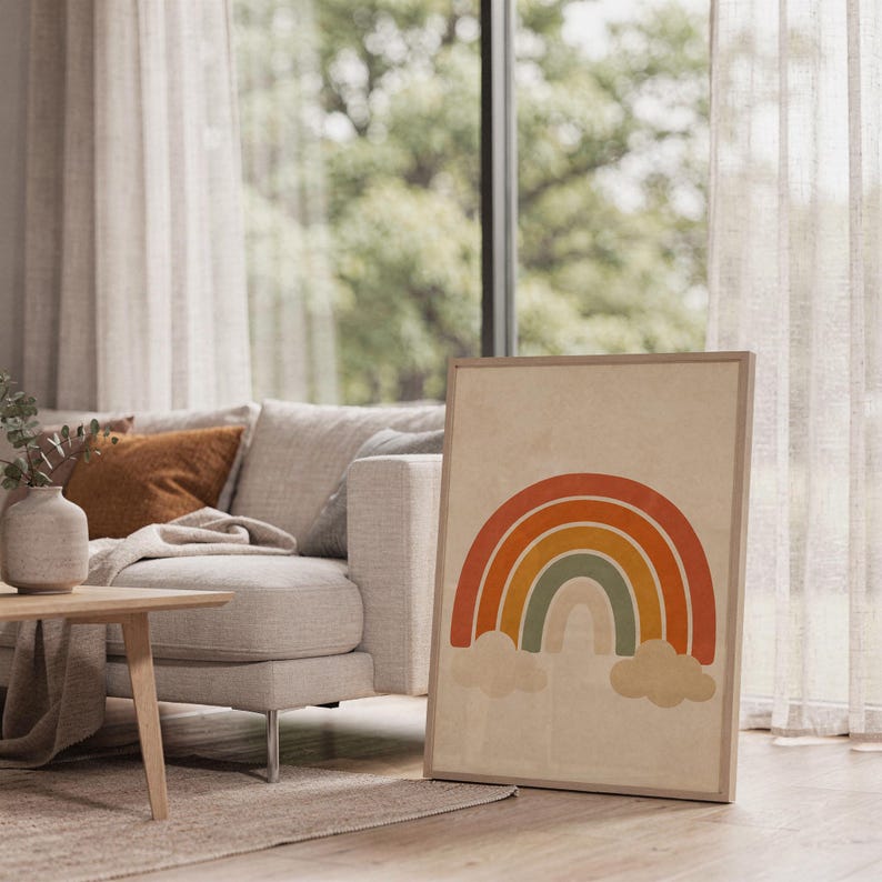 Boho earth tone rainbow print leaning on the floor beside a cream armchair next to large garden windows.
