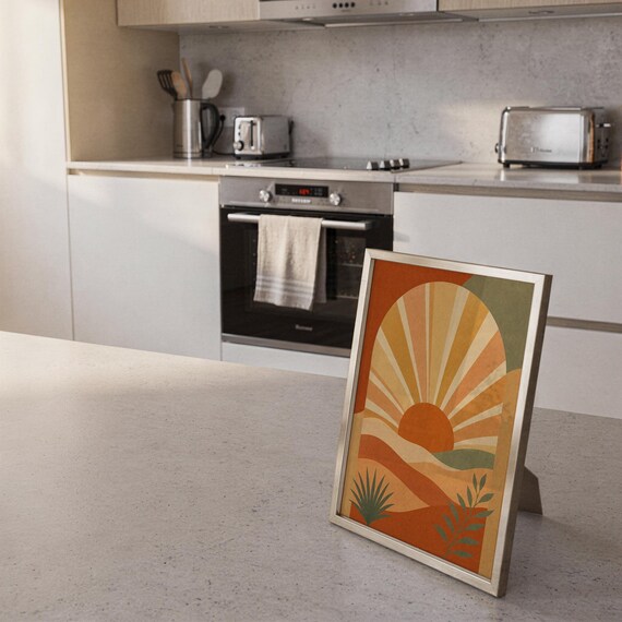 Boho sun arch print standing on a countertop in a modern white kitchen.
