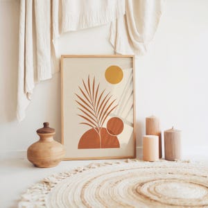Mid century palm leaf poster resting on floor with boho woven rug and cushions