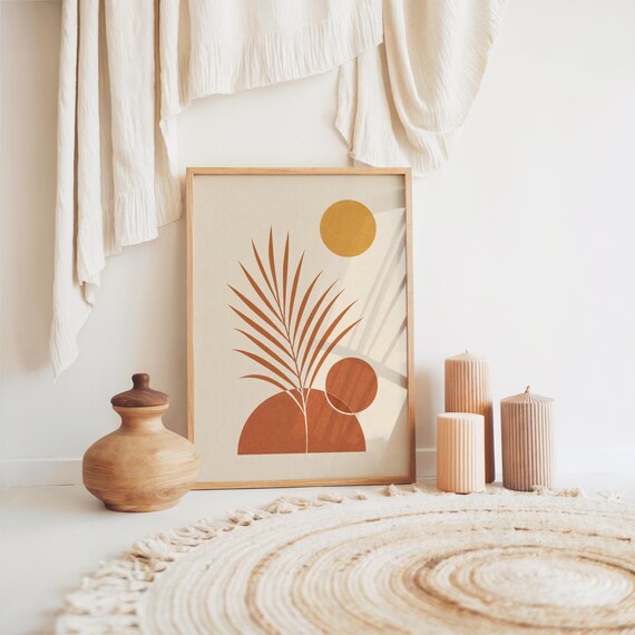 Mid century palm leaf poster resting on floor with boho woven rug and cushions
