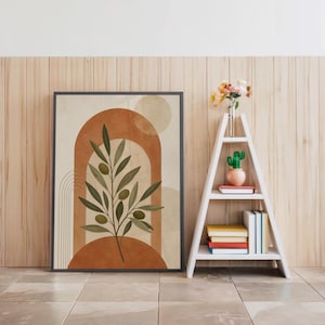 Terracotta arch poster in black frame beside white decorative ladder shelf