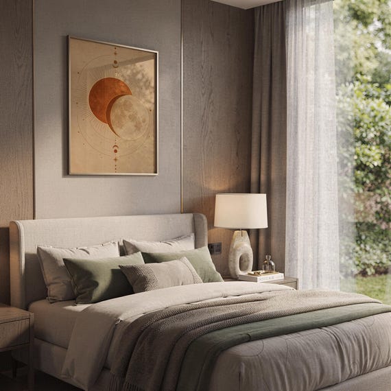 Sun and moon celestial wall art print hanging above a bed with sage green pillows in a calm neutral bedroom.