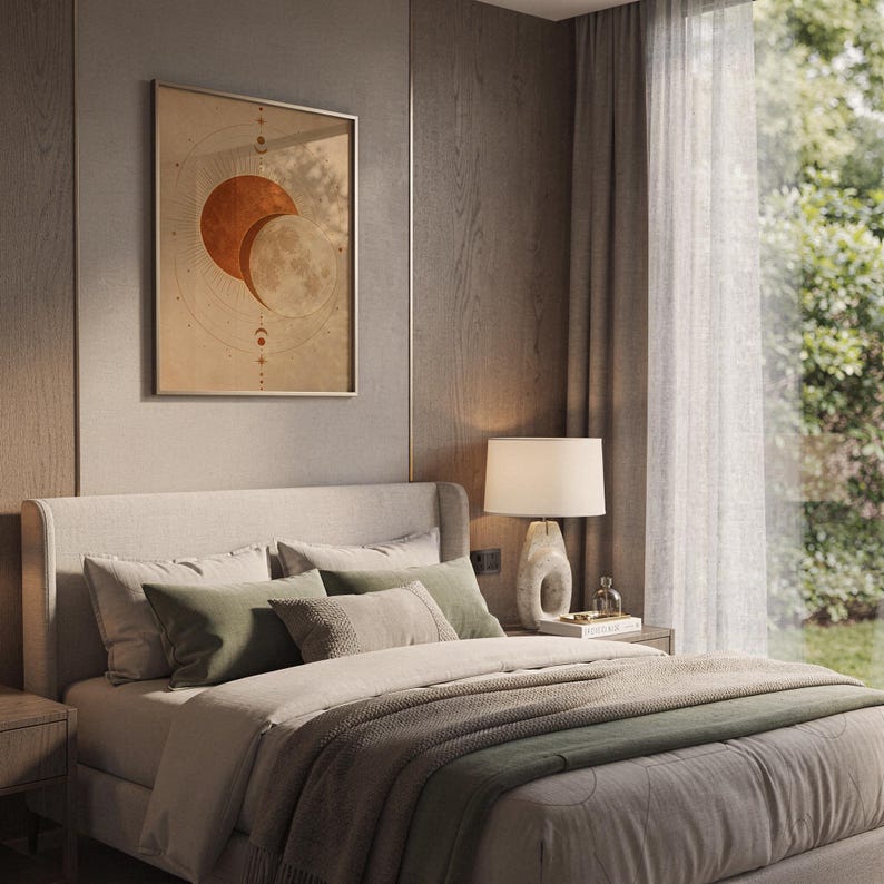 Sun and moon celestial wall art print hanging above a bed with sage green pillows in a calm neutral bedroom.