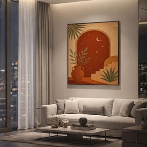 Terracotta moon and stars arch art print showing a terracotta arched doorway under a night sky with a crescent moon and small stars, curved stairs, a clay vase and palm leaves, hanging above a light gray sofa in a modern living room with evening city views through tall windows.