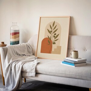 Earthy green olive branch poster resting next to light gray sofa