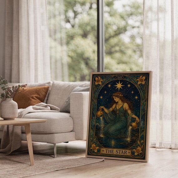 The star tarot card wall art print leaning on the floor beside a cream armchair next to large garden windows.